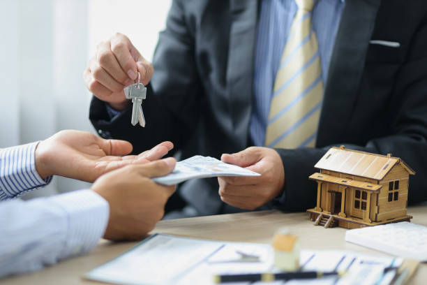 The real estate agent or seller receives money and gives the customer the house keys after the purchase agreement is reached.