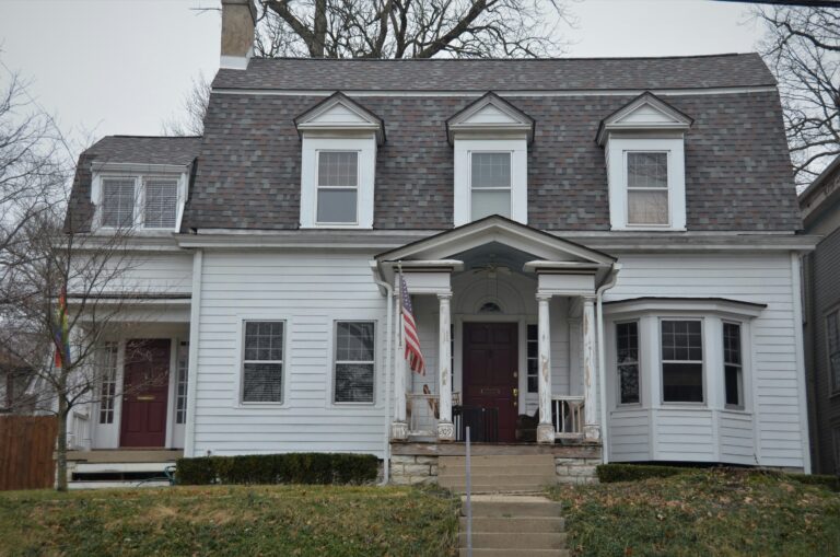 white and gray wooden house near green grass during daytime