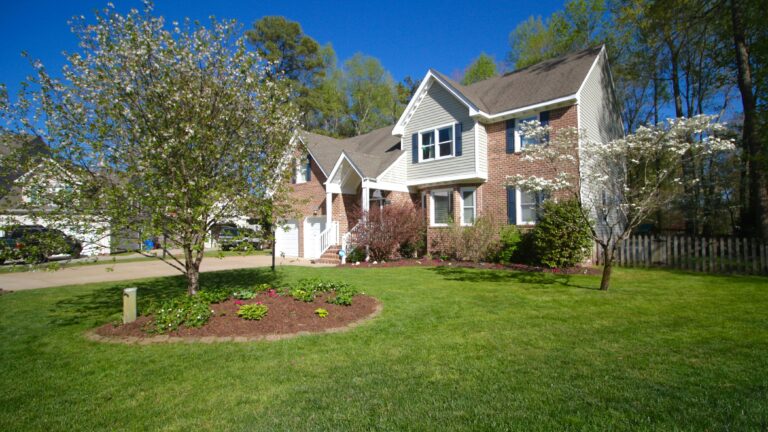 a brick house with a tree in front yard