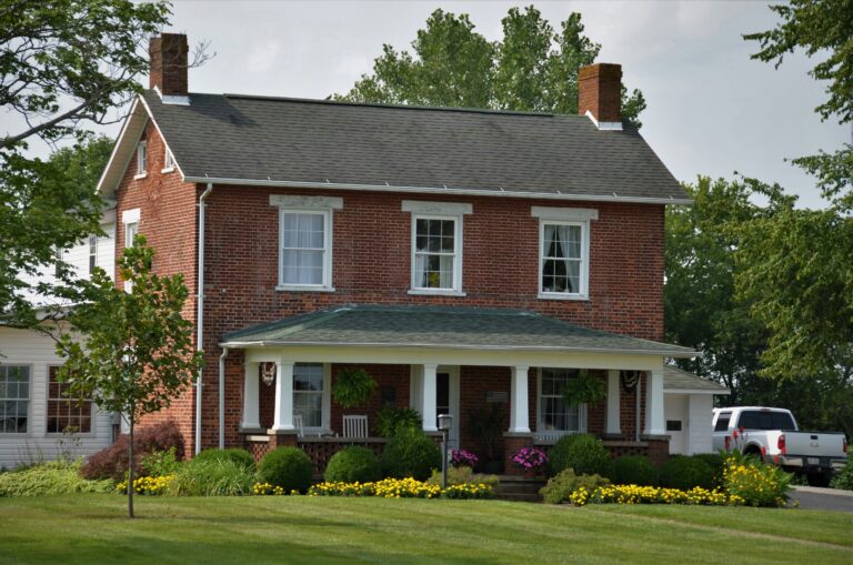 colonial brick house near green grass field