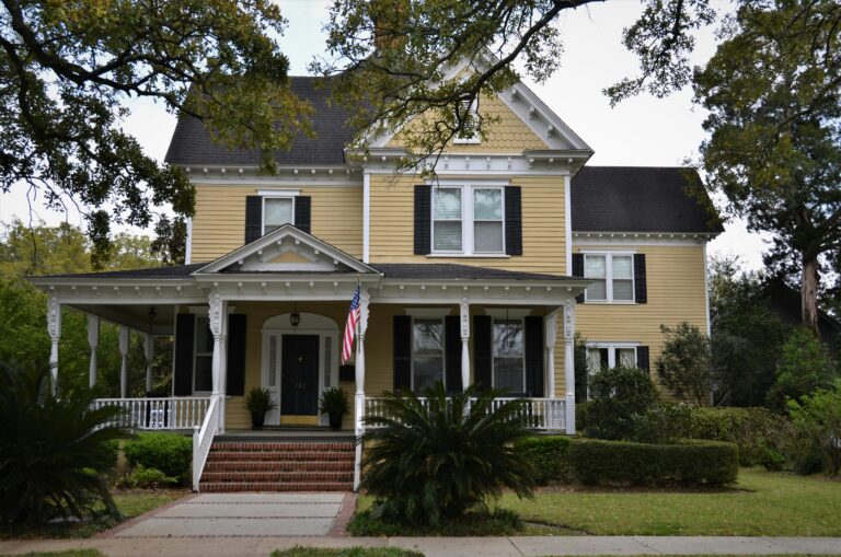 a yellow house with a flag on the porch