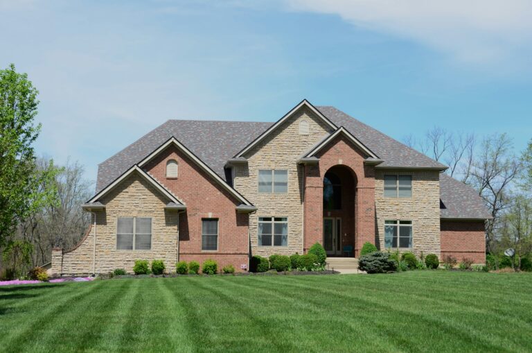 a large brick house with grass in frontyard
