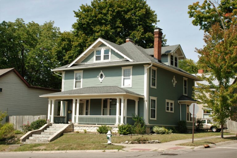 white and gray house near green trees during daytime
