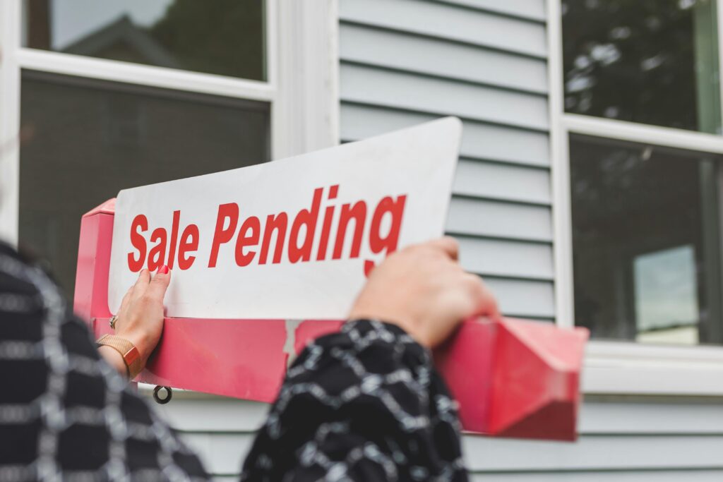 person holding a signage outside the house