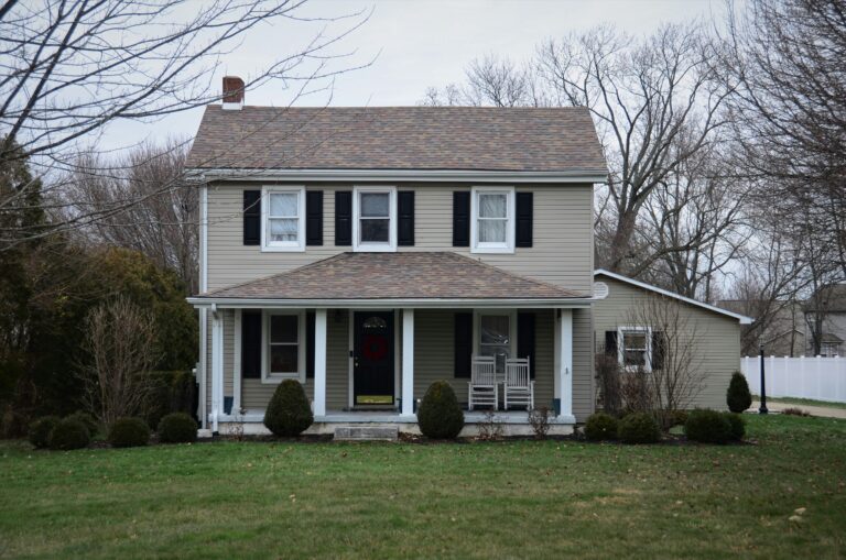 white and brown two story house on a grassy field