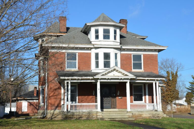 a large brick home with white porch