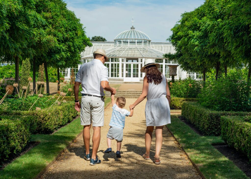 man and woman holding a childs hands while walking