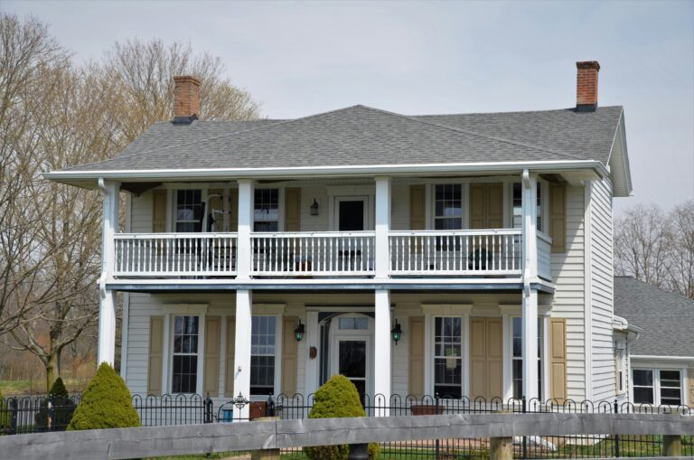 white and brown house near green trees during daytime