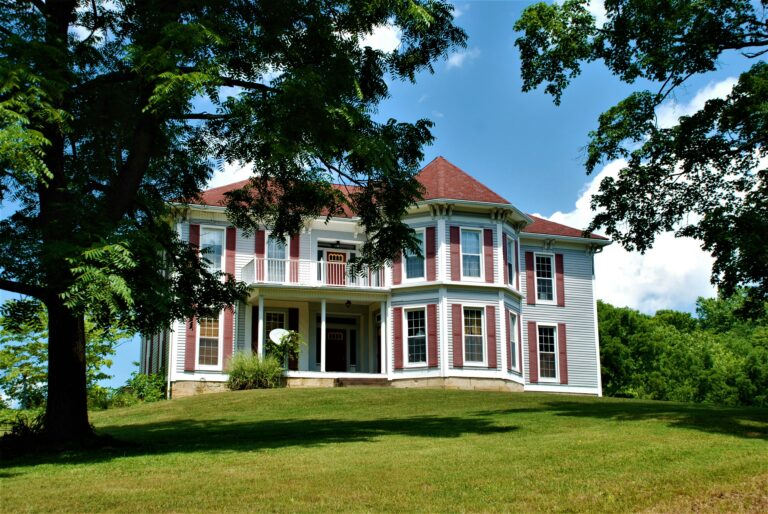 white and blue house near green trees during daytime