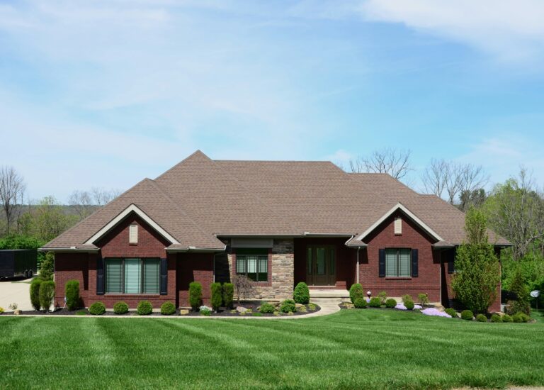 a red brick house with a large lawn in front