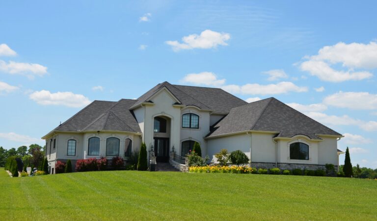 a modern country home sitting on top of lush green field