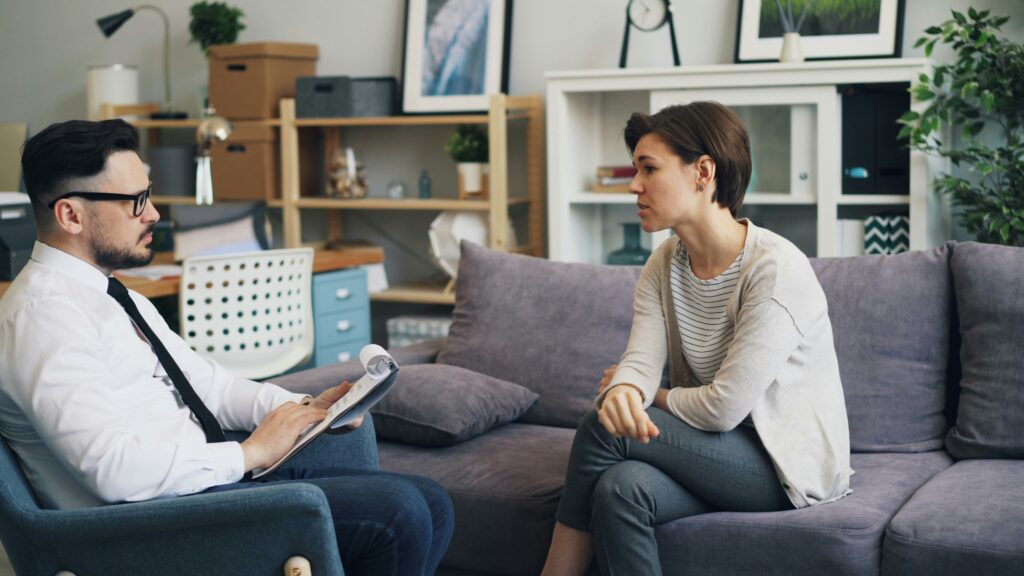 a man and a woman sitting on a couch talking
